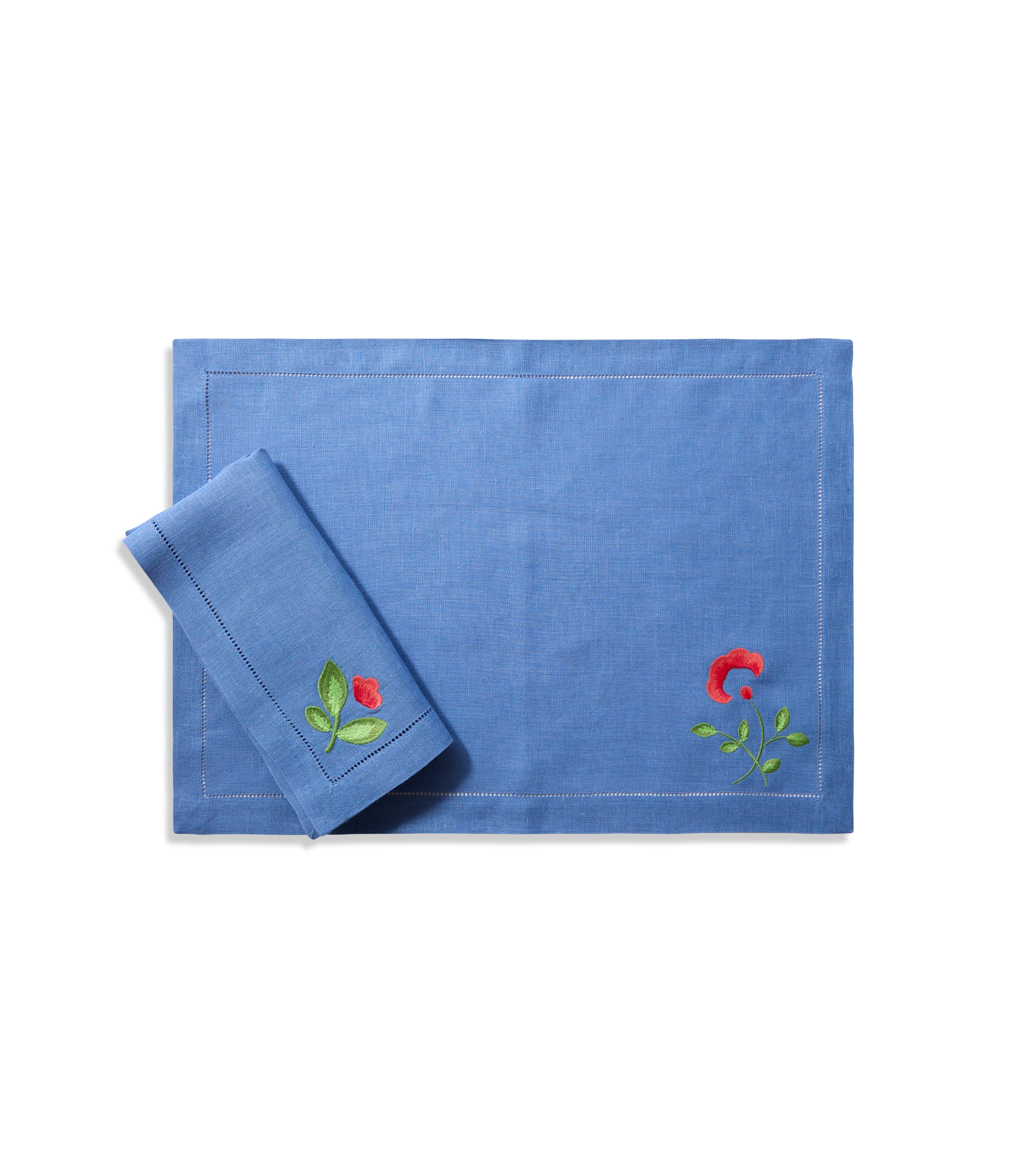 Blue linen placemat with red and green floral corner embroidery.