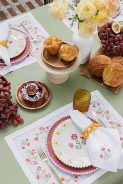 table setting with white linen placemat and napkin with flower embroidery