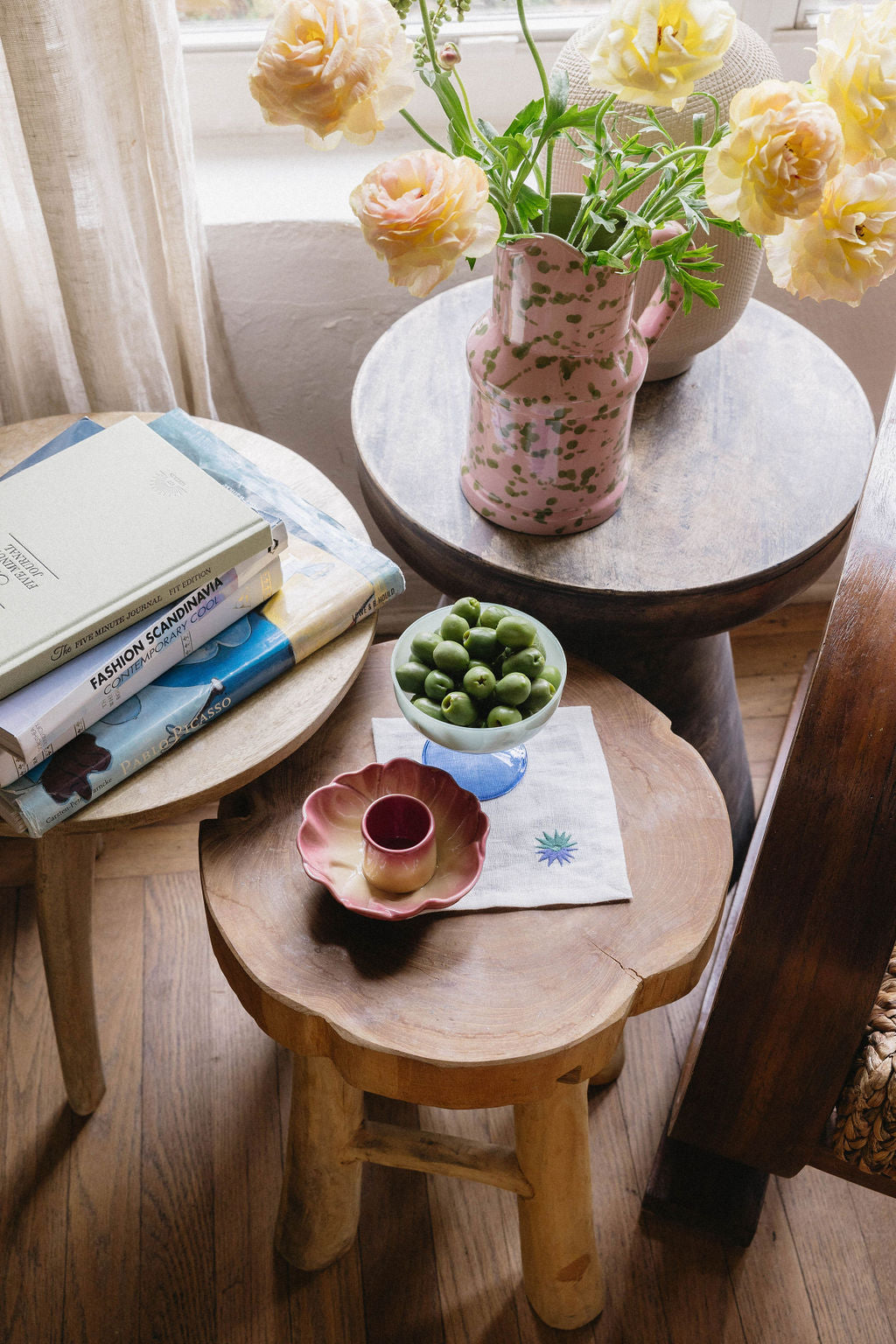 Table setting with linen napkin, pitcher with flowers and bowl with olives