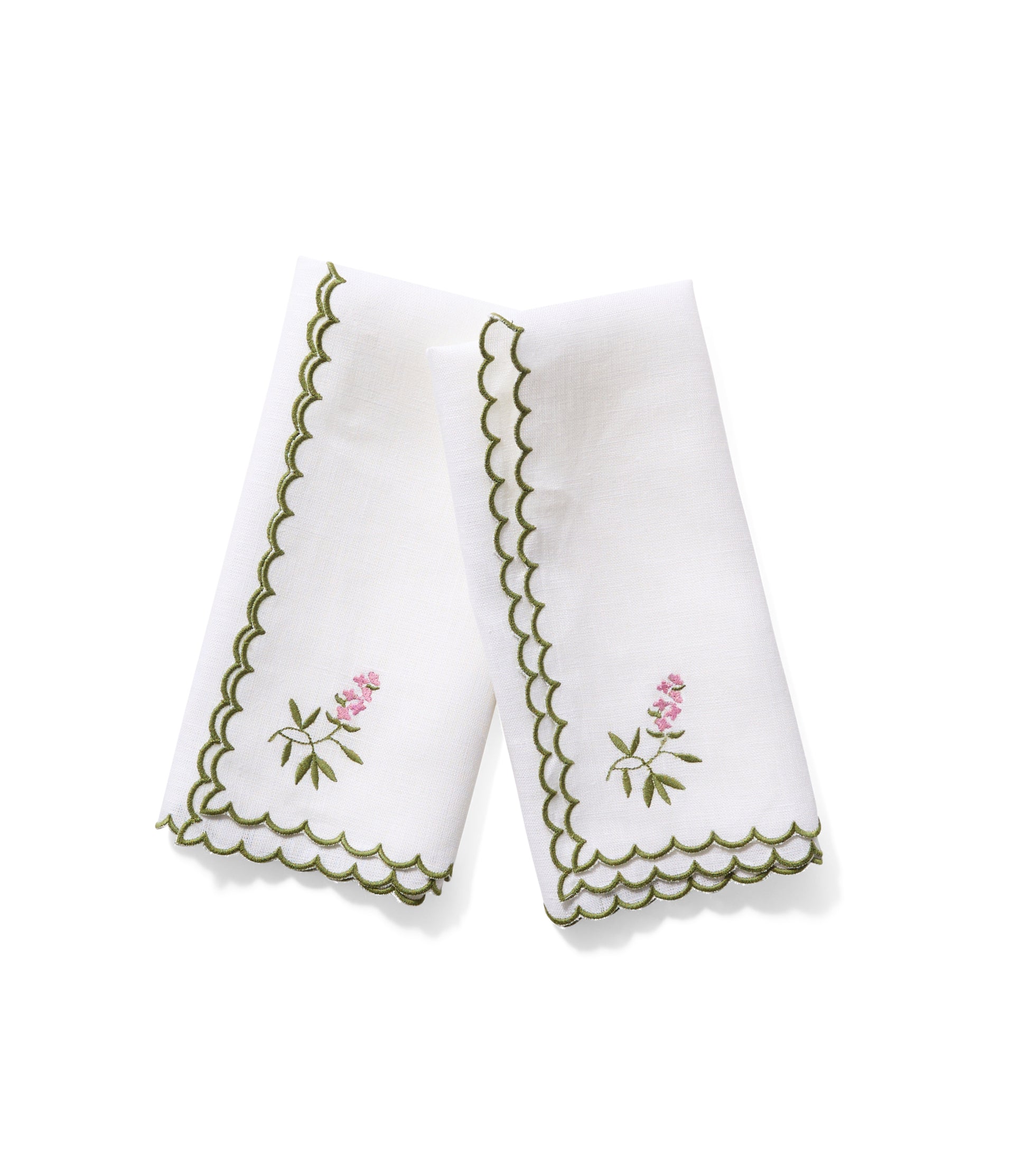 White linen napkin with green scallop edge embroidery and lavender corner motif.