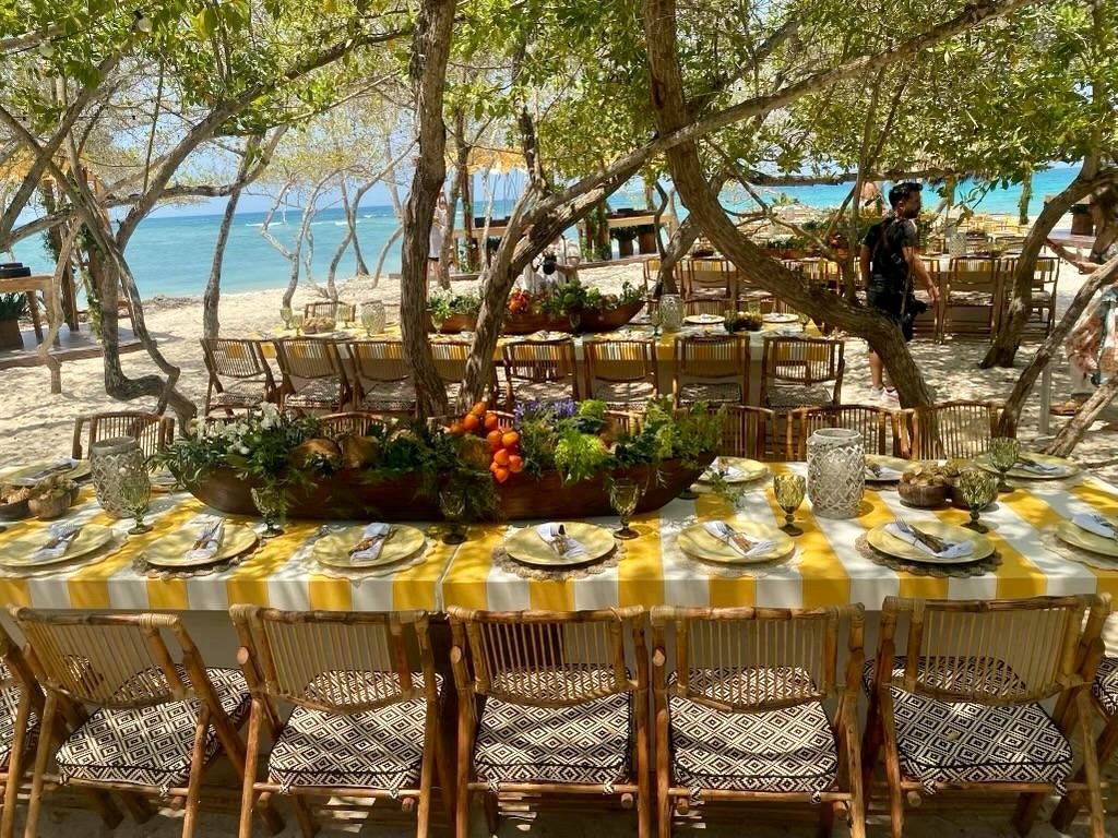 A long family table set beside the sea at Isla Capricho